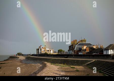 Sheerness, Kent, Großbritannien. Oktober 2023. Wetter in Großbritannien: Ein atemberaubender, lebhafter Regenbogen scheint am Isle of Sheppey Sailing Club zu enden, der heute Nachmittag bei einem vorbeiziehenden Regenschauer in Sheerness, Kent, zu sehen ist. Quelle: James Bell/Alamy Live News Stockfoto