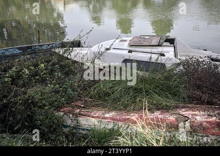 Verlassenes Boot am Seeufer und Reflektionen von Bäumen im Wasser Stockfoto