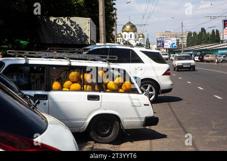 Autos, die dicht am Lebensmittelmarkt in Odessa, Ukraine, geparkt werden. Der alte Lada ist voll mit Melonen, die Räder hängen, es ist August und die Bauern beeilen sich Stockfoto