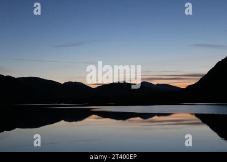 Blaue Stunde beim Treffen der Gewässer im Killarney National Park, County Kerry, Irland im Winter. Wunderschöne Berge in der Abenddämmerung in einem See Stockfoto