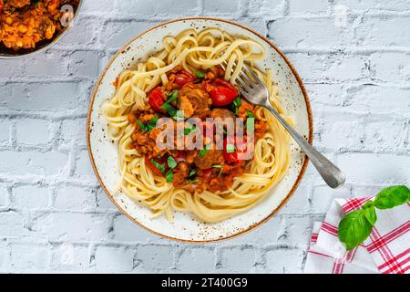 Fleischbällchen in Tomaten- und Linsensauce mit Linguinnudeln Stockfoto
