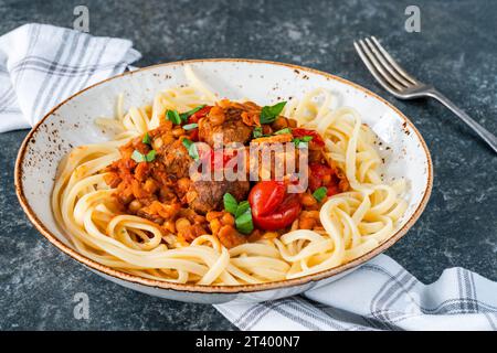 Fleischbällchen in Tomaten- und Linsensauce mit Linguinnudeln Stockfoto