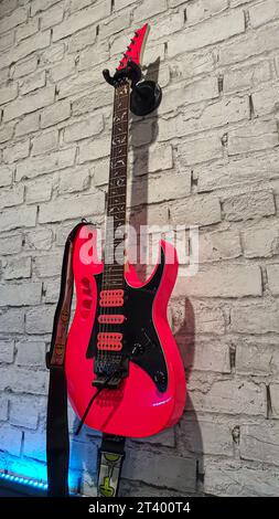 Elektrische Gitarre. Rotes Musikinstrument an einer Betonwand. Kopierbereich Stockfoto