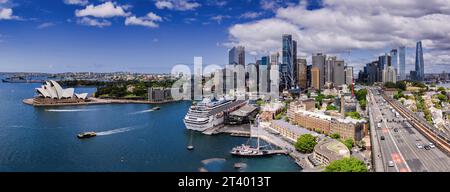 Ein Blick aus der Vogelperspektive auf ein großes Boot, das friedlich in einem Gewässer an einer Skyline der Stadt schwimmt Stockfoto
