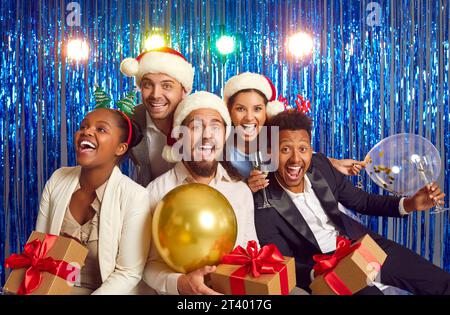 Porträt multinationaler glücklicher Kollegen in Santa Hats während des Neujahrsfotos auf einer Firmenfeier. Stockfoto