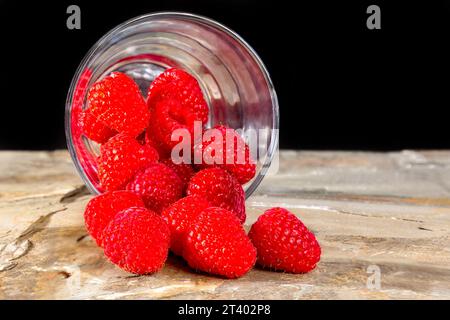 Frische Himbeeren in einem Glas auf einer Steinoberfläche, Kopierraum Stockfoto