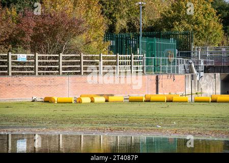 Taplow, Großbritannien. Oktober 2023. Heute gab es eine große Menge weißen Schaum auf dem Jubilee River in Taplow, Buckinghamshire. Der Jubilee River ist ein von Menschenhand geschaffenes Hochwasserschutzsystem, das von der Umweltbehörde verwaltet wird und bei starkem Regen überschüssiges Wasser aufnimmt und so dazu beiträgt, Windsor, Maidenhead und Dorney vor Überschwemmungen zu schützen. Pflanzenschutt, brauner Schlamm und Entengras haben sich hinter dem gelben Bummel am Wehr zurückgebildet, aber im eigentlichen Wehr am Jubliee River und danach gab es viel mehr weißen Schaum als sonst auf der Oberfläche des Flusses heute. Es ist möglich, dass dies der Fall ist Stockfoto