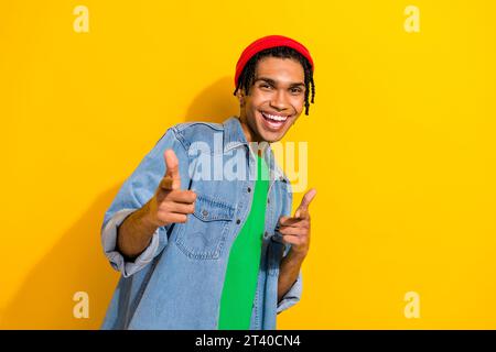 Foto-Porträt der süßen jungen männlichen Finger Punkt leer Sie aufgeregt gekleidete stilvolle Jeans Kleid isoliert auf gelbem Hintergrund Stockfoto