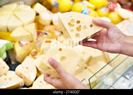 Käse in den Händen eines Käufers in einem Geschäft Stockfoto