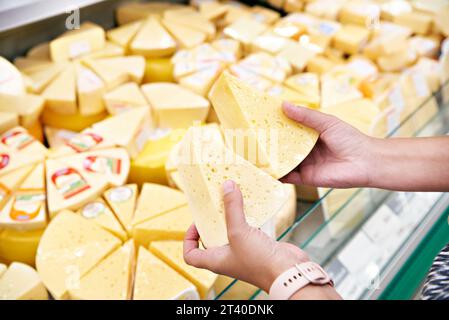 Käse in den Händen eines Käufers in einem Geschäft Stockfoto