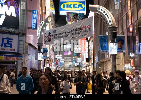 Tokio, Japan. Oktober 2023. Tokyoiten und Touristen feiern Halloween unter einem Banner, das Halloween-Feiern in Shibuya verbietet. Shibuya Bürgermeister Ken Hasebe, ermutigt durch die Itaewon-Katastrophe in Seoul, hat Halloween-Feiern verboten und ausländische Touristen gewarnt, sich von Shibuya fernzuhalten, nachdem sie eine mehrjährige Kampagne durchgeführt hatten, um die Volksversammlung zu töten, indem sie vor einer potenziellen Schreckenssituation warnten, obwohl es keine Vorfälle gab, die eine Katastrophe in Tokio nach Itaewon-Art zur Kontrolle der Menschenmenge beinhalteten. Trinken und Rauchen sind in Shibuya-ku an Halloween vorübergehend verboten. (Bild: © Taidgh Barron/ZUMA Pres Stockfoto