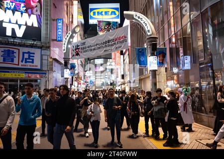 Tokio, Japan. Oktober 2023. Tokyoiten und Touristen feiern Halloween unter einem Banner, das Halloween-Feiern in Shibuya verbietet. Shibuya Bürgermeister Ken Hasebe, ermutigt durch die Itaewon-Katastrophe in Seoul, hat Halloween-Feiern verboten und ausländische Touristen gewarnt, sich von Shibuya fernzuhalten, nachdem sie eine mehrjährige Kampagne durchgeführt hatten, um die Volksversammlung zu töten, indem sie vor einer potenziellen Schreckenssituation warnten, obwohl es keine Vorfälle gab, die eine Katastrophe in Tokio nach Itaewon-Art zur Kontrolle der Menschenmenge beinhalteten. Trinken und Rauchen sind in Shibuya-ku an Halloween vorübergehend verboten. (Bild: © Taidgh Barron/ZUMA Pres Stockfoto