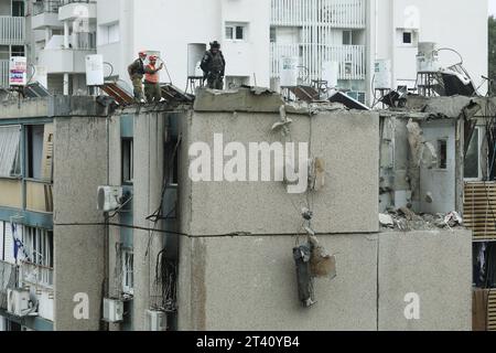 (231027) -- TEL AVIV, 27. Oktober 2023 (Xinhua) -- Mitglieder israelischer Sicherheitskräfte inspizieren ein Gebäude, das bei einem Raketenangriff aus Gaza am 27. Oktober 2023 in Tel Aviv, Israel, beschädigt wurde. Die israelischen Verteidigungskräfte (IDF) dehnen die Bodenoperationen in Gaza am Freitagabend aus, um die in den letzten Tagen durchgeführte Offensive fortzusetzen, sagte IDF-Sprecher Daniel Hagari. Unterdessen schossen bewaffnete palästinensische Fraktionen Raketen auf israelische Städte als Vergeltungsmaßnahme, so israelische Medienberichte. (Gideon Markowicz/JINI via Xinhua) Stockfoto