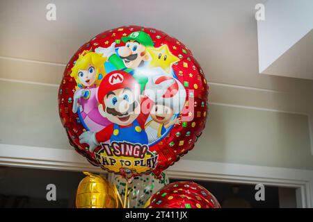 Schöne Szene mit großen Helium-gefüllten Ballons mit beliebten Zeichentrickfiguren in der gemütlichen Wohnung, die Freude und Spaß in den Raum bringen. Stockfoto