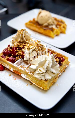 Speculoos liege Waffel mit Eis und Brüsseler Waffel mit Erdbeeren und Schlagsahne im Maison Dandoy, Royal Gallery of Saint Hubert, Brussel Stockfoto