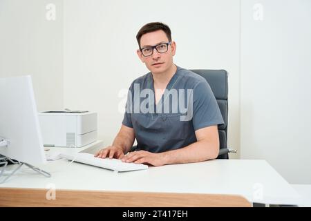 Der Arzt arbeitet an einem Computer am Arbeitsplatz Stockfoto