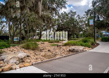 Bradenton, Florida im Manatee County. Szenen entlang des Bradenton Riverwalk mit Parkschildern und architektonischen Strukturen. Der Manatee River auf Fotos Stockfoto