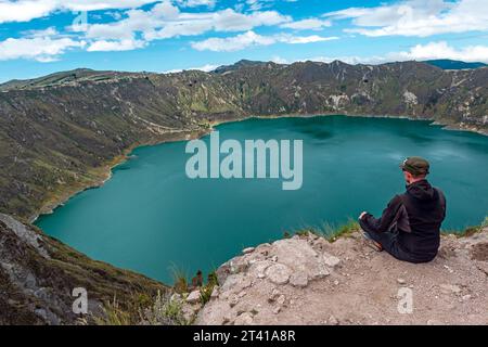 Männlicher Touristenwanderer mit Blick über den Quilotoa See entlang der Quilotoa Lagoon Loop, Anden Berge, Quito Region, Ecuador. Stockfoto