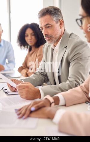 Geschäftiger leitender indischer Geschäftsmann Investor, der bei der Bürositzung Rechtsdokumente liest. Stockfoto