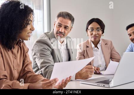 Vielbeschäftigtes, vielseitiges Business Executive Team, das bei Gruppenbesprechungen mit Laptop arbeitet. Stockfoto