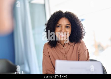 Junge glückliche afroamerikanische Geschäftsfrau beim Meeting beim Zuhören beim Meeting. Stockfoto