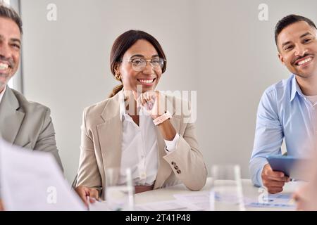 Glückliche Geschäftsfrau, die während eines Geschäftsgruppensitzes kommuniziert. Stockfoto