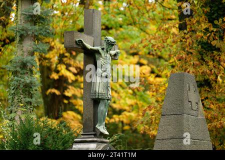 Historisches Kruzifix auf einem Herbstfriedhof in köln Stockfoto