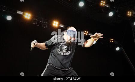Ein Mann mit Stirnband, der auf der Bühne singt Stockfoto