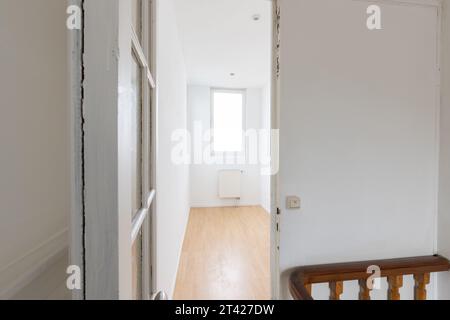 Ein Flur mit einem wunderschönen Holzboden und kontrastierenden weißen Wänden Stockfoto