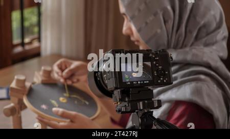 Nähen Tutorial Delight: Nähte für Damenhände auf dunklem Stoff Stockfoto