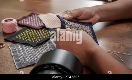 Nähen Tutorial Delight: Nähte für Damenhände auf dunklem Stoff Stockfoto