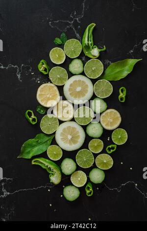 Eine Auswahl an reifem Obst und Gemüse auf einer schwarzen Arbeitsplatte Stockfoto