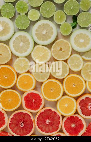 Eine lebendige Darstellung von Zitrusfrüchten, bestehend aus Limetten und Zitronen in verschiedenen auf einem Holztisch Stockfoto