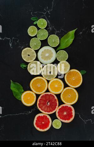 Eine Vielzahl von bunten Früchten, darunter Äpfel, Orangen, Trauben und Bananen, angeordnet in einer turmähnlichen Struktur auf einer weißen Oberfläche Stockfoto