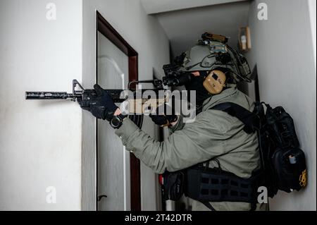 Ein Soldat der militärischen Spezialkräfte steht in einer Tür, während er Gebäude mit Nachtsicht räumt Stockfoto