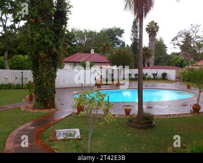 Dieser Pool im Hinterhof ist von einem lebhaften grünen Rasen und üppigem Grün umgeben und bietet eine ruhige und einladende Atmosphäre Stockfoto