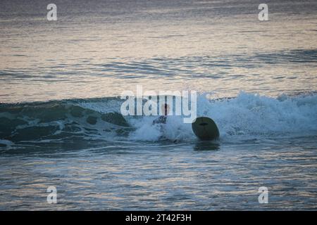 Ein nicht erkennbarer Surfer fällt in einer Welle auf ein SUP-Board. Action, Urlaub, aktive Erholung am Meer, Reisen. Stockfoto