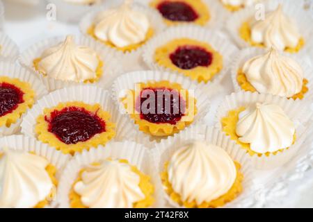 Ein Blick von oben auf einen Teller farbenfroher Desserts, umgeben von anderen verlockenden Speisen Stockfoto