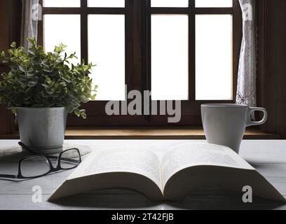 Ein offenes Buch auf einem Holztisch vor dem transparenten Hintergrund Stockfoto