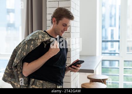 Junger Soldat, der zu Hause kommuniziert. Stockfoto