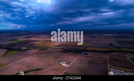 Eine Panoramasicht bietet eine weitläufige Landschaft mit einem Feld von Feldfrüchten und Straßen vor einem bewölkten Himmel Stockfoto