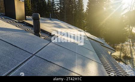Nahaufnahme der Drohne von frostigen Solarpaneelen auf dem Dach eines Privathauses, sonniger Morgen Stockfoto