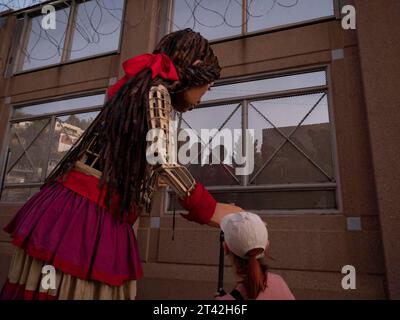 Nogales, Arizona, USA. Oktober 2023. Die kleine Amal, die 12-Fuß-Marionette eines syrischen Flüchtlingsmädchens, begrüßt die Jugendlichen auf der mexikanischen Seite der Grenzmauer. Little Amal ist auf einer 6000 km langen Reise durch die Vereinigten Staaten, um auf die Notlage von Migranten und Flüchtlingen aufmerksam zu machen und gleichzeitig mit lokalen Kunst- und Gemeindeorganisationen zusammenzuarbeiten. (Credit Image: © Sue Dorfman/ZUMA Press Wire) NUR REDAKTIONELLE VERWENDUNG! Nicht für kommerzielle ZWECKE! Stockfoto