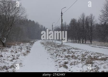 Eine leere Straße im Schnee. Schneebedeckter Pfad. Winter auf der Straße. Schnee auf der Piste. Stockfoto