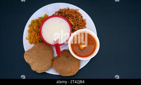 Indisches Essen - Puri Bhaji und Kheer. Nordindische halbtrockene Kartoffelwürze, auch bekannt als Batata oder Aloo KI Sabji, Kartoffelcurry oder Dum Alu Curry Stockfoto