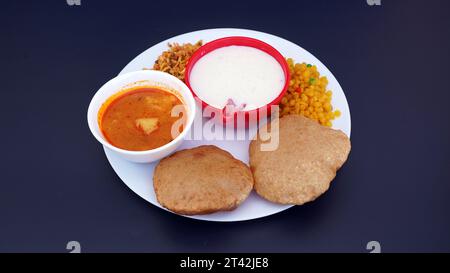 Indisches Essen - Puri Bhaji und Kheer. Nordindische halbtrockene Kartoffelwürze, auch bekannt als Batata oder Aloo KI Sabji, Kartoffelcurry oder Dum Alu Curry Stockfoto