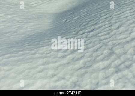 Textur von Frühlingsschnee. Eisschicht. Details der Winternatur. Schneedecke. Stockfoto