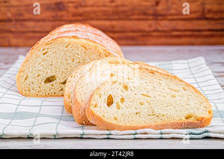 Mehrere Weißbrotscheiben, eine teilweise mit einem Messer in zwei Hälften geschnitten Stockfoto