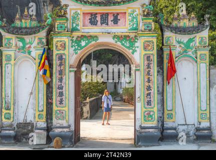 Ein Mann, der vor einem offenen Steinbogen in einer asiatischen Umgebung steht Stockfoto