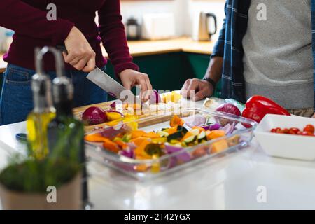 Mitte des kaukasischen Paares, das Essen zubereitete, Gemüse in der Küche hackte, Kopierraum Stockfoto